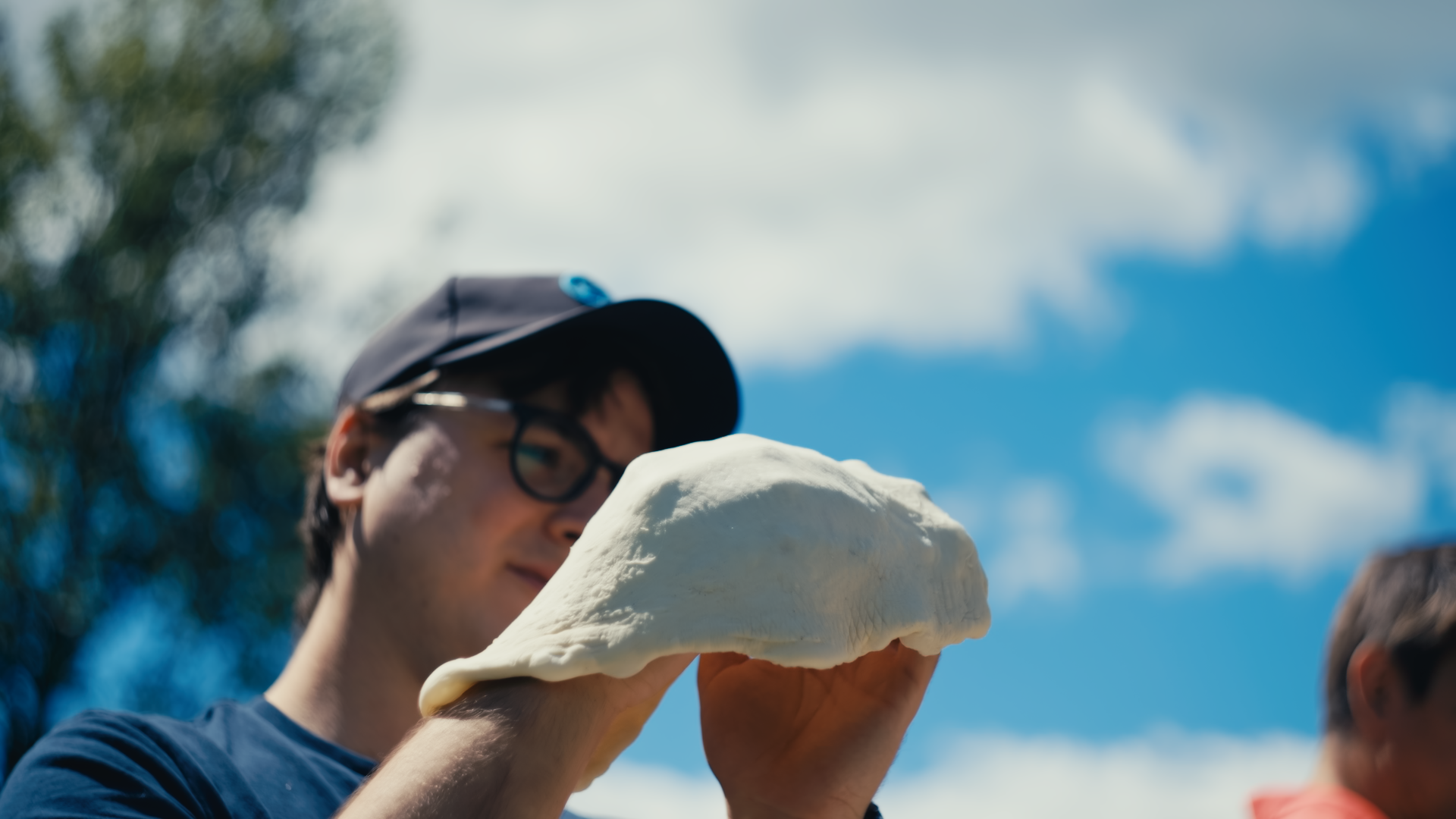Marketing Manager, Eric, tossing pizza dough 